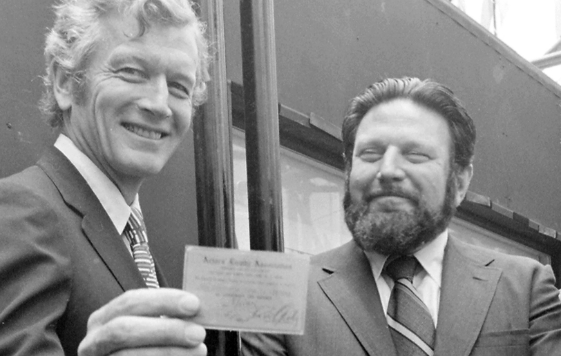 Actors Equity president Theodore Bikel presents a life membership card to John Lindsay at the opening of the Times Square Theatre Center (TKTS) at Broadway and 47th Street