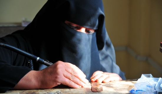 Woman in niqab making handicrafts