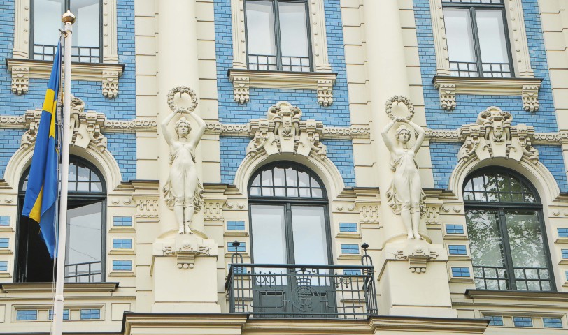 Façade by Mikhail Eisenstein of two women carrying crown of leaves, 1904