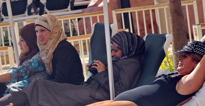 Arab women enjoy the suns rays at the pool